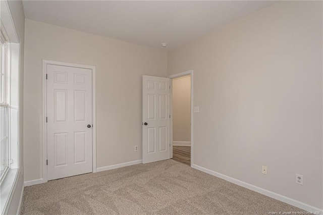 unfurnished bedroom with carpet floors and baseboards