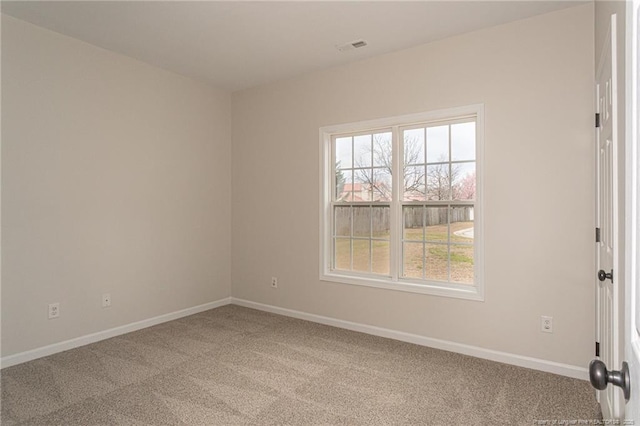 carpeted empty room with visible vents and baseboards