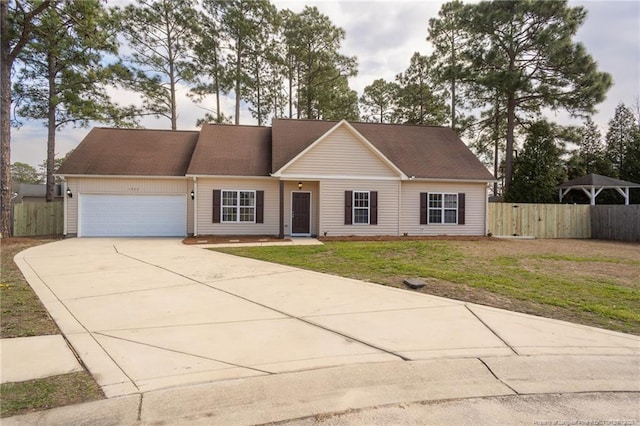 view of front of home featuring a garage, driveway, a front yard, and fence