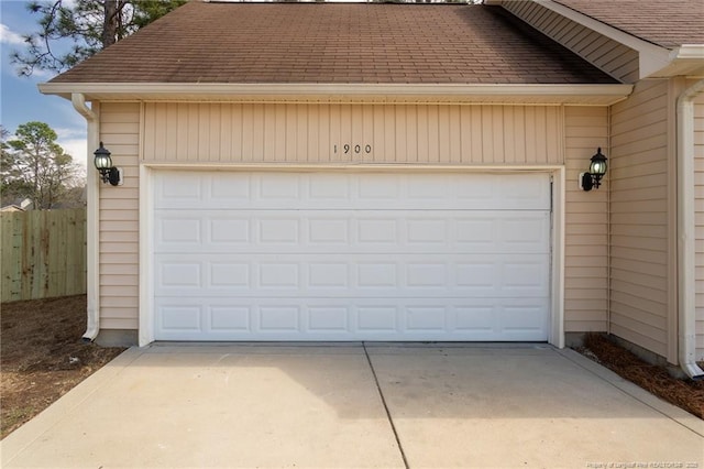 garage with driveway and fence