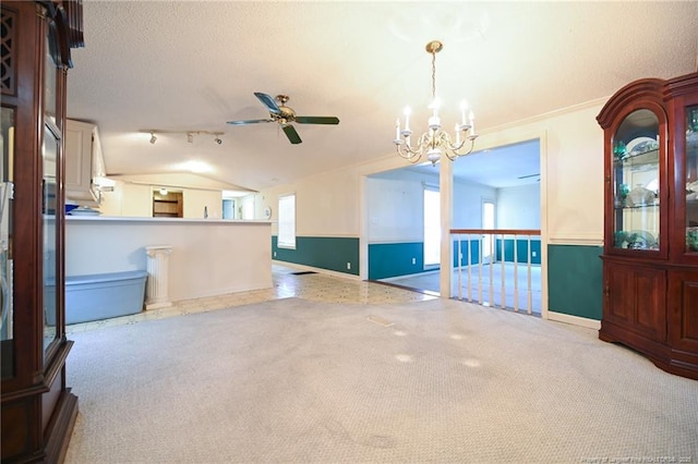 unfurnished room with carpet, lofted ceiling, a textured ceiling, baseboards, and ceiling fan with notable chandelier