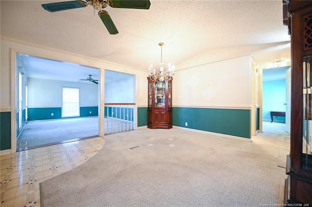 empty room with carpet, lofted ceiling, a textured ceiling, baseboards, and ceiling fan with notable chandelier