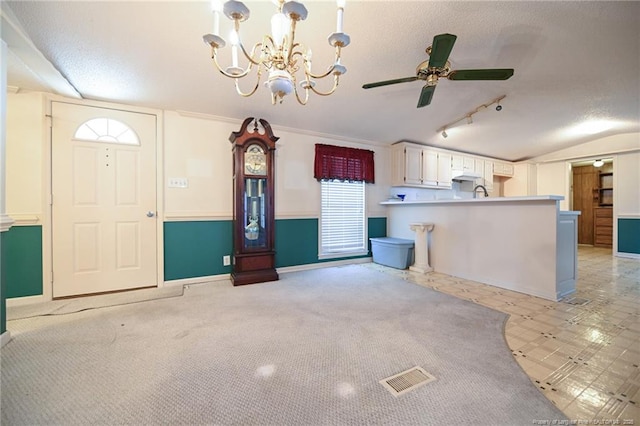 interior space with a textured ceiling, visible vents, baseboards, vaulted ceiling, and a ceiling fan