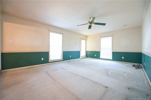 spare room with a healthy amount of sunlight, baseboards, a ceiling fan, and carpet flooring