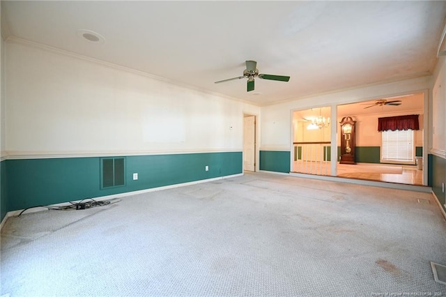 empty room with ceiling fan with notable chandelier, visible vents, baseboards, carpet, and crown molding