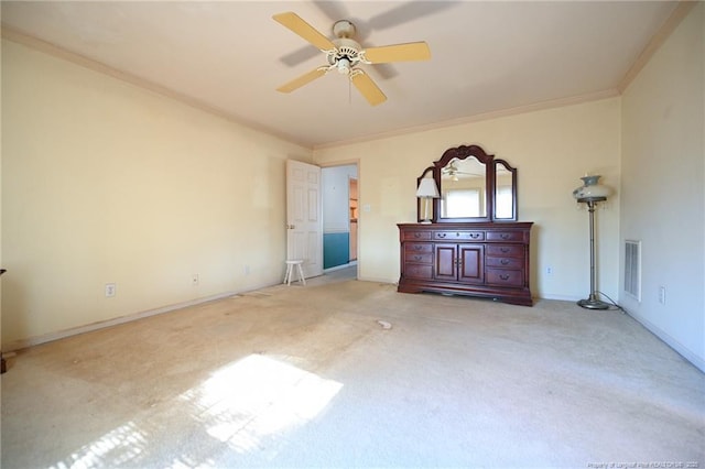 unfurnished bedroom featuring visible vents, baseboards, a ceiling fan, ornamental molding, and carpet flooring