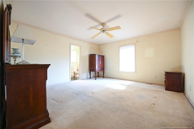 unfurnished bedroom featuring ensuite bathroom, carpet flooring, a ceiling fan, and crown molding