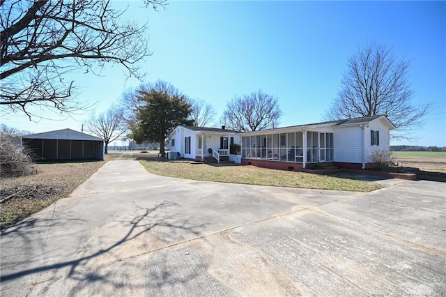 ranch-style house with a sunroom and a front yard