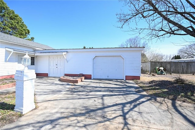 garage with driveway and fence