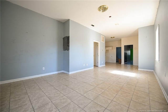 empty room featuring visible vents, baseboards, and light tile patterned floors