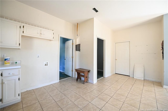 kitchen featuring light tile patterned floors, baseboards, white cabinetry, and light countertops