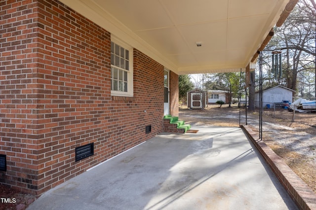 view of patio / terrace featuring an outbuilding, fence, and a storage shed