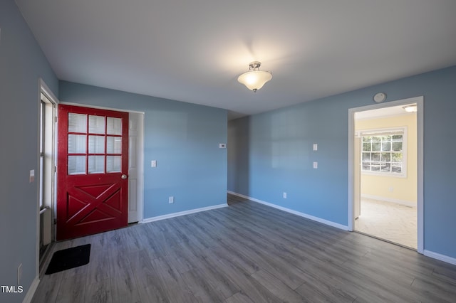 spare room with baseboards and dark wood-style flooring