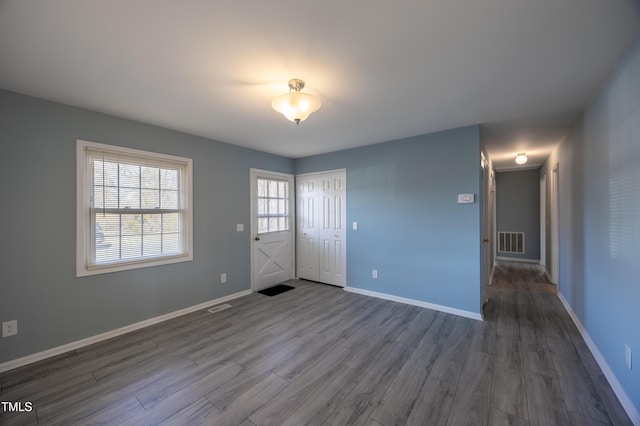 interior space with baseboards, visible vents, and wood finished floors