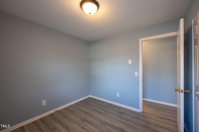 unfurnished room featuring dark wood-style floors and baseboards