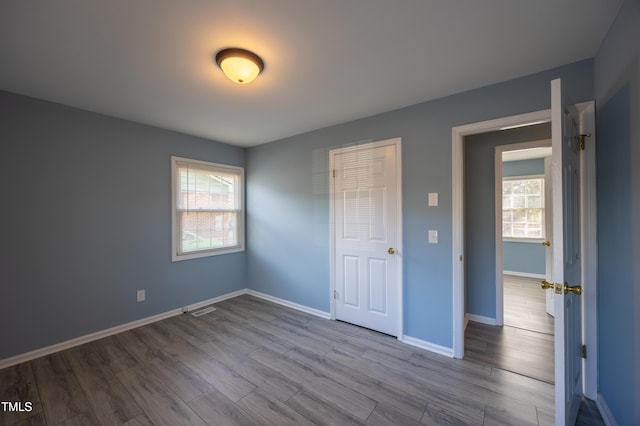 unfurnished bedroom with dark wood-style flooring and baseboards