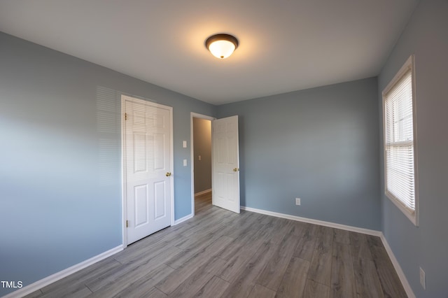 unfurnished bedroom with baseboards and wood finished floors