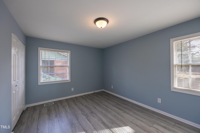 spare room featuring a wealth of natural light, visible vents, and baseboards