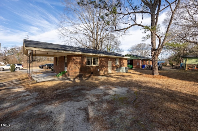 exterior space featuring crawl space, an attached carport, and brick siding