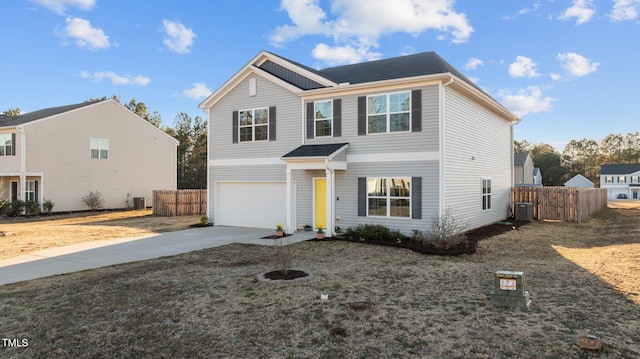 traditional-style home with fence, driveway, an attached garage, and central AC unit