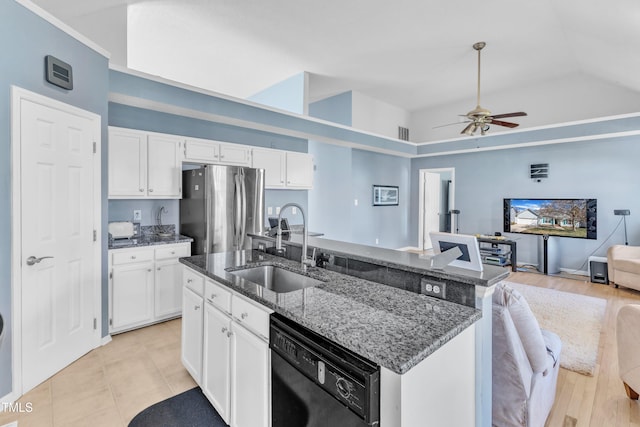 kitchen with a sink, black dishwasher, open floor plan, freestanding refrigerator, and dark stone countertops