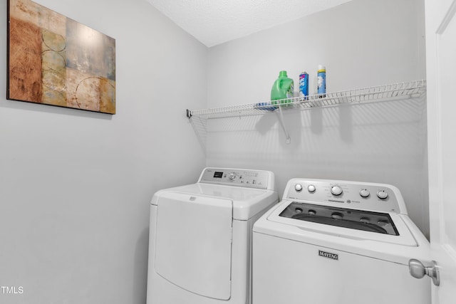 laundry room with washing machine and dryer, laundry area, and a textured ceiling