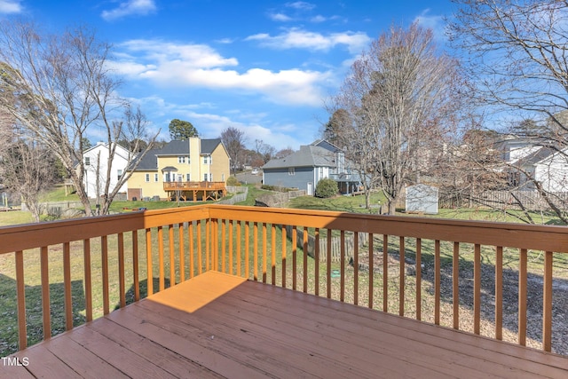 wooden deck with a residential view and a lawn