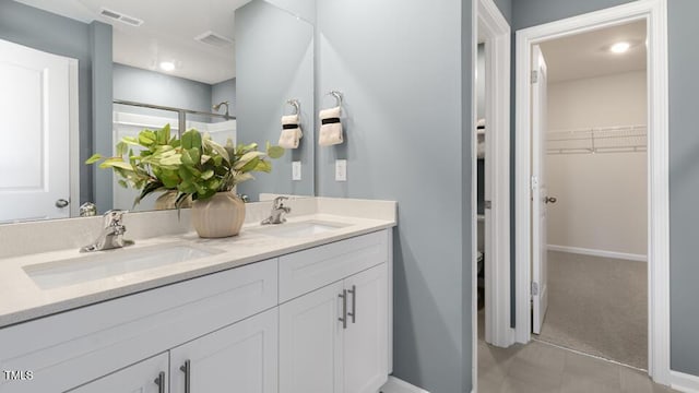 150 Ethel Ln, Angier, NC 27501 - bathroom with double vanity, baseboards, a walk in closet, and a shower