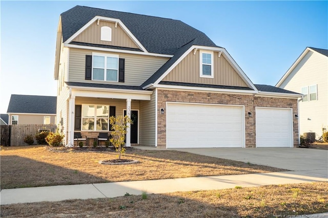 craftsman inspired home featuring covered porch, a garage, fence, concrete driveway, and board and batten siding