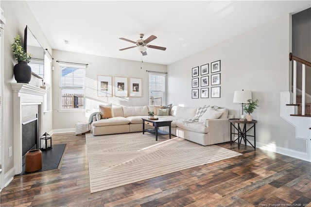 living room featuring baseboards, ceiling fan, stairway, wood finished floors, and a fireplace