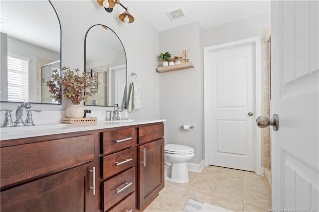 bathroom with toilet, a sink, visible vents, double vanity, and a stall shower