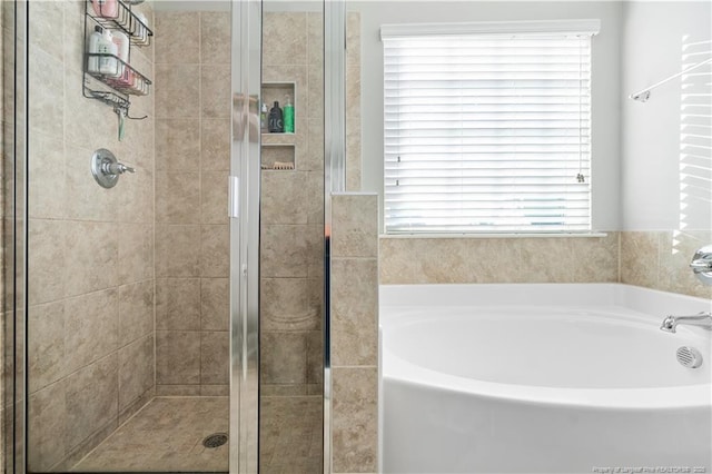 bathroom with a garden tub and a shower stall