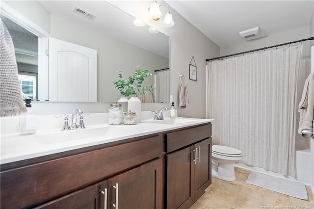 bathroom with toilet, double vanity, visible vents, and a sink