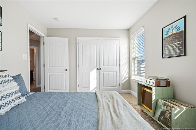 bedroom with carpet floors, a closet, and baseboards