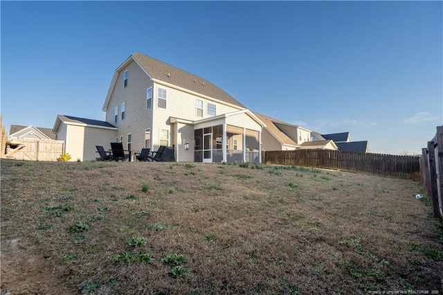 back of property with a sunroom and a fenced backyard