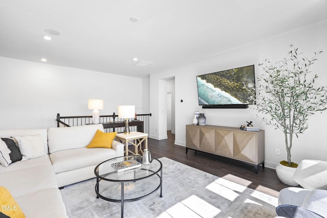 living room featuring visible vents, baseboards, wood finished floors, and recessed lighting