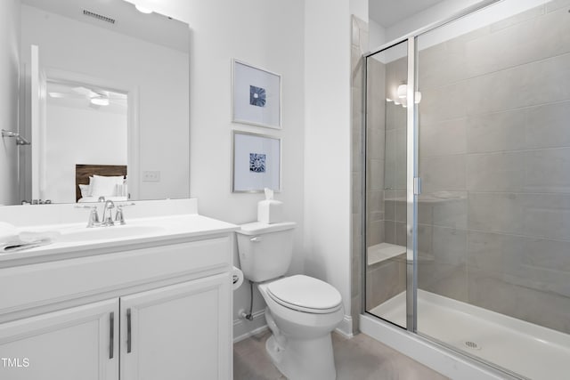 full bathroom with toilet, vanity, visible vents, baseboards, and a shower stall