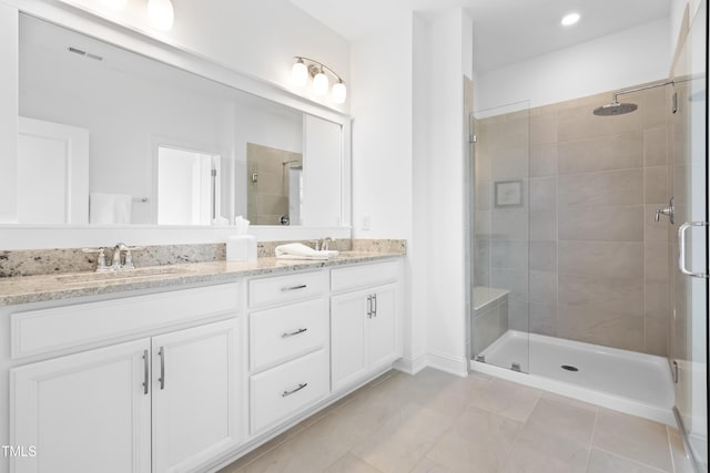 full bathroom with a sink, visible vents, tile patterned floors, double vanity, and a stall shower