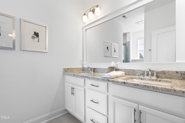 bathroom featuring double vanity, a sink, visible vents, and baseboards