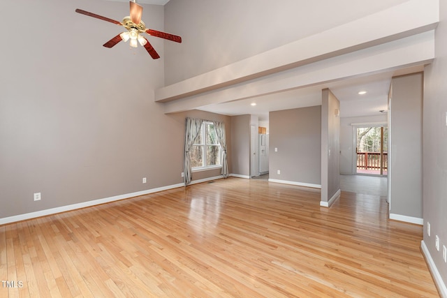 unfurnished room with recessed lighting, a high ceiling, a ceiling fan, baseboards, and light wood-type flooring