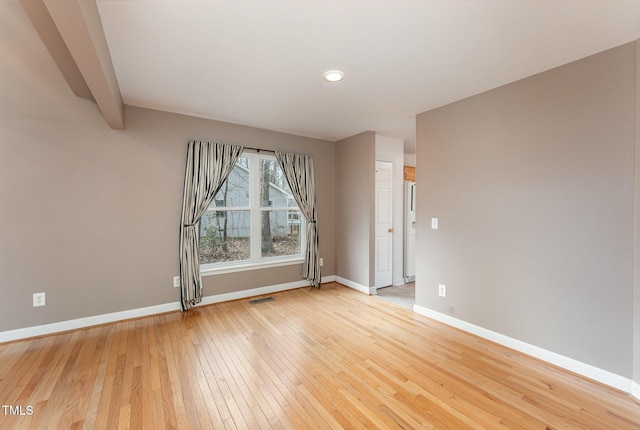 spare room with baseboards, visible vents, and light wood-style floors