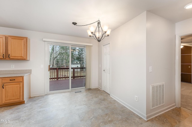 unfurnished dining area with an inviting chandelier, baseboards, and visible vents