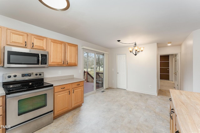 kitchen featuring a chandelier, baseboards, light countertops, appliances with stainless steel finishes, and light brown cabinetry