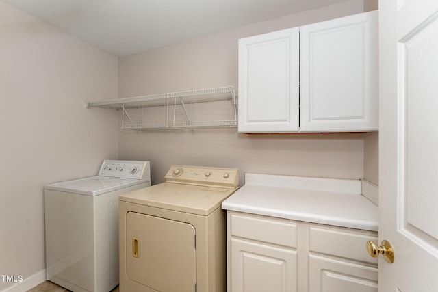 washroom featuring cabinet space and washer and clothes dryer