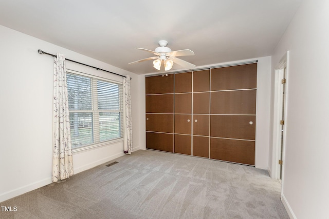 unfurnished bedroom featuring a ceiling fan, carpet flooring, visible vents, and baseboards