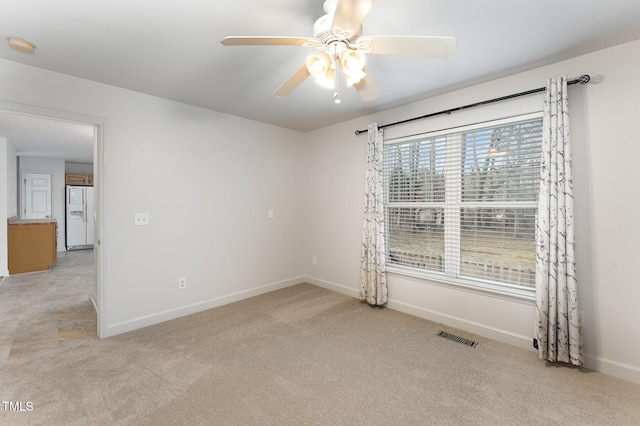 unfurnished room featuring light carpet, baseboards, visible vents, and a ceiling fan