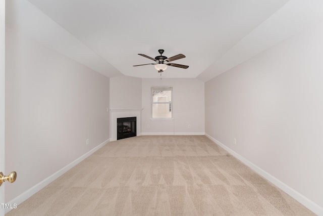 unfurnished living room featuring light colored carpet, a fireplace, baseboards, and ceiling fan