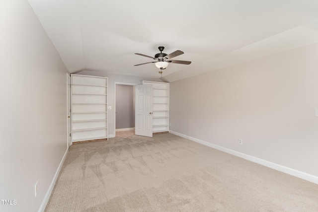 unfurnished bedroom featuring a ceiling fan, light colored carpet, and baseboards