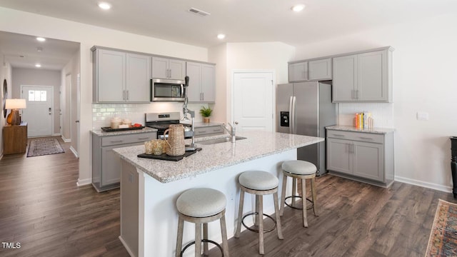 kitchen featuring stainless steel appliances, gray cabinets, and visible vents