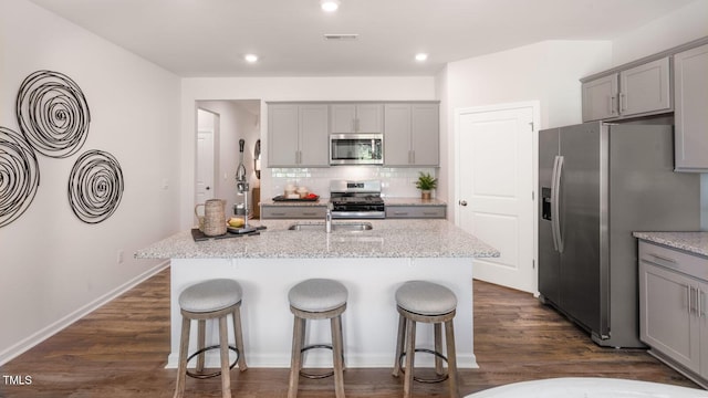 kitchen with stainless steel appliances, visible vents, gray cabinets, and backsplash